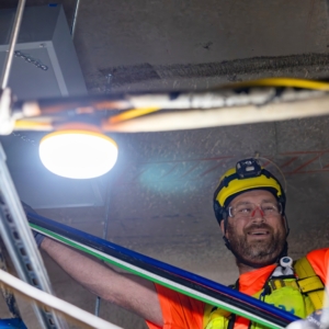 Male electrician wires lighting in a commercial building.