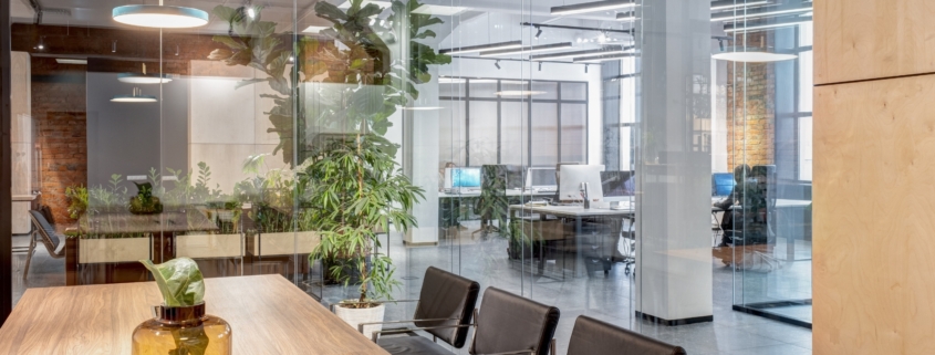 Modern office with glass walls, conference room, and open workspace.