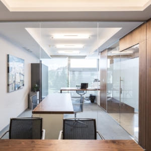 Modern office with large windows and wood desk.