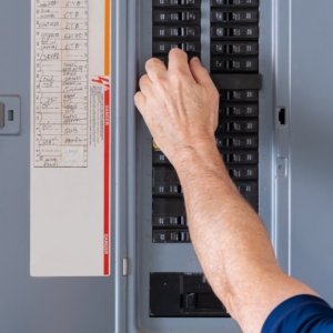 Man adjusting his home's electrical panel.