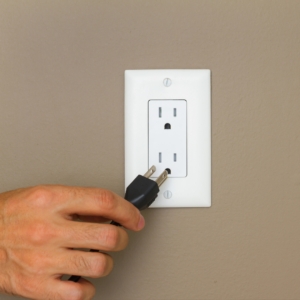 Man plugging a cord into a socket.