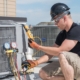 HVAC technician on the roof of a home performing a maintenance check.