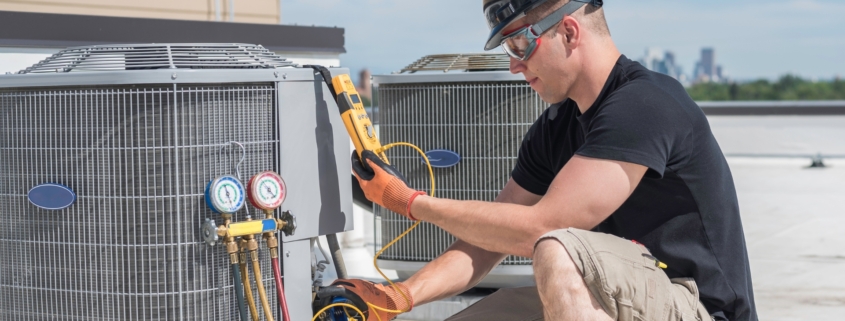 HVAC technician on the roof of a home performing a maintenance check.