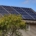 Solar panels on the roof of a home with tan siding.