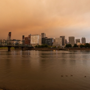 City by the ocean in summer with orange haze in the sky.