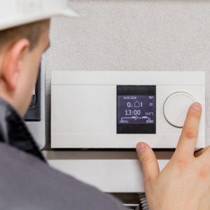 Electrician fixing a home thermostat.
