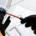 Electrician wears safety gloves while fixing a home electrical socket.