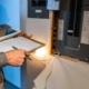 Residential electrician with clipboard tests a home electrical panel.