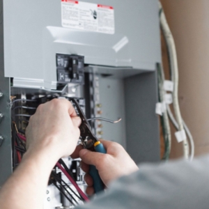 Residential electrician fixing a home's electrical panel.