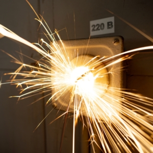 Yellow sparks shooting out from a white electrical panel.