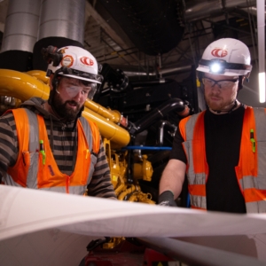 Two commercial electricians review blueprints.