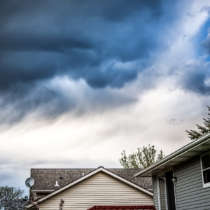 Dark gray clouds above two homes.