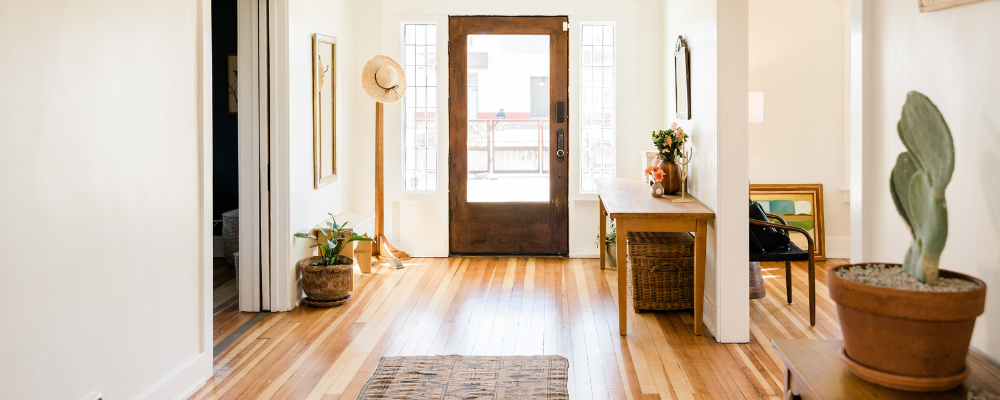 Interior of home's entryway with hardwood floors and plants.