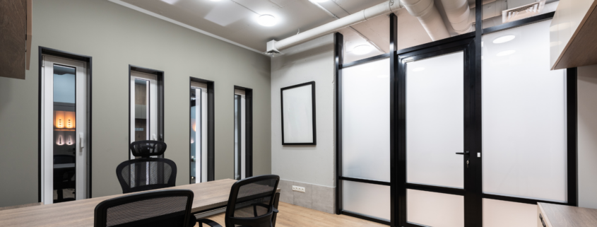 Office with conference table and black chairs.