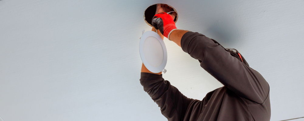 Commercial electrician changing a light fixture.
