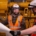 Electrical contractors discussing blueprint in industrial setting.