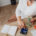 Woman in white shirt pays bills while sitting at her desk.