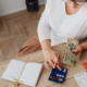 Woman in white shirt pays bills while sitting at her desk.