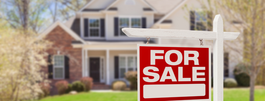 A for sale sign in front of a house.